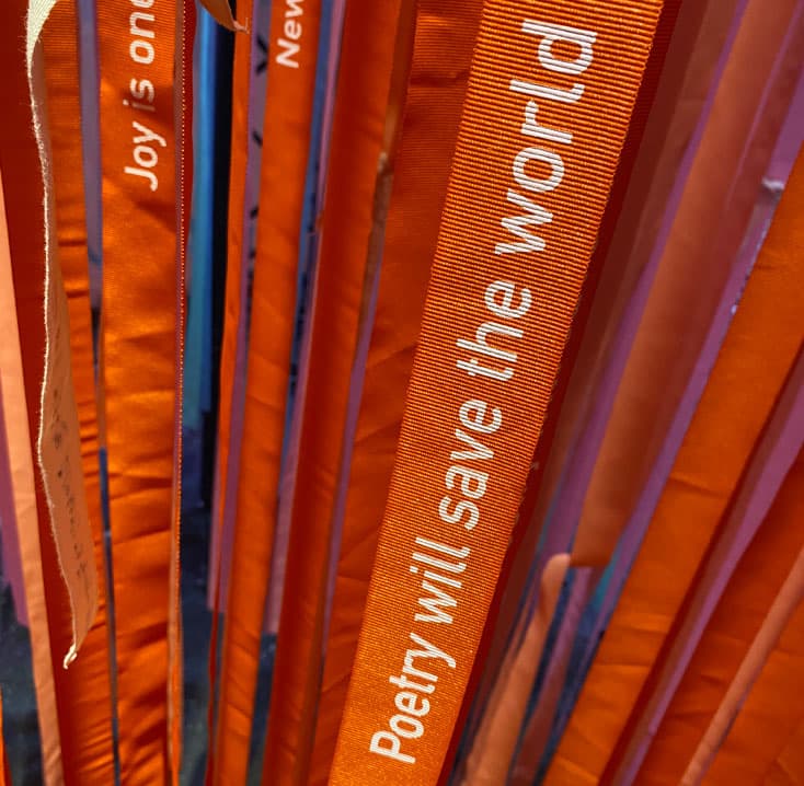 une oeuvre compoése de nombreux rubans suspendus avec des messages inscrits dessus